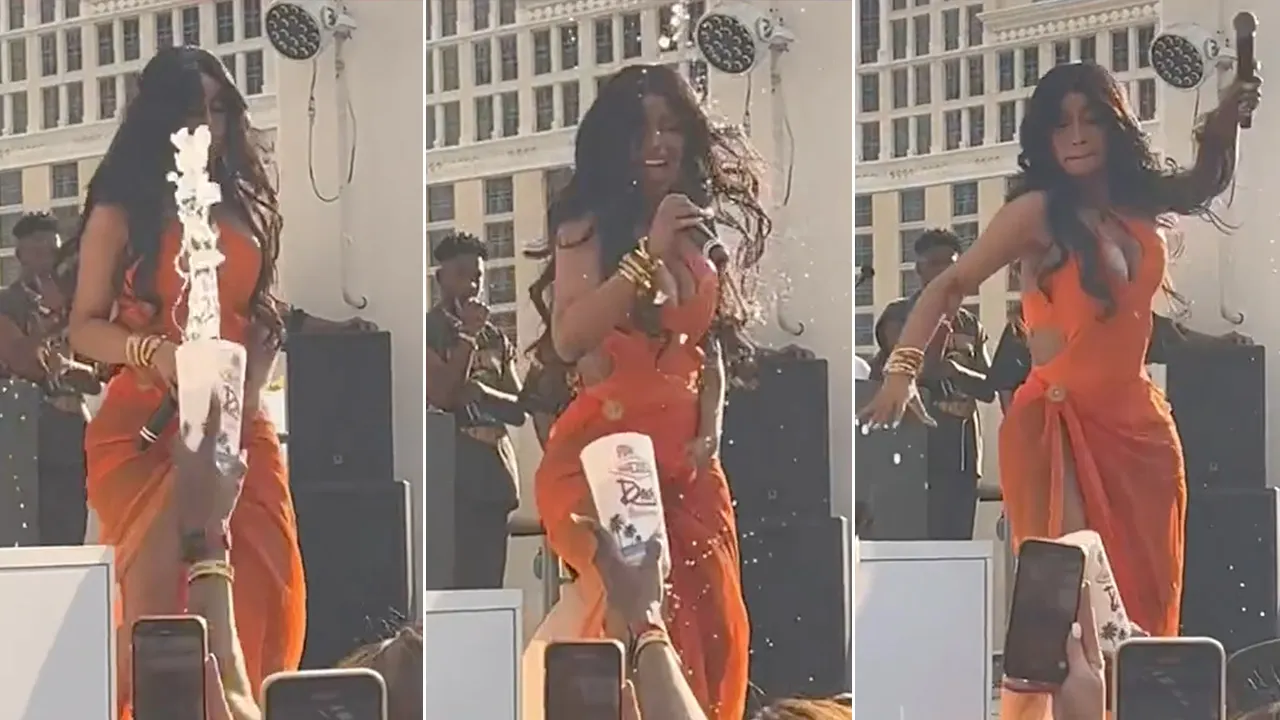 Cardi B gets splashed with beverage, Cardi B reacts, Cardi B winds up to throw microphone
