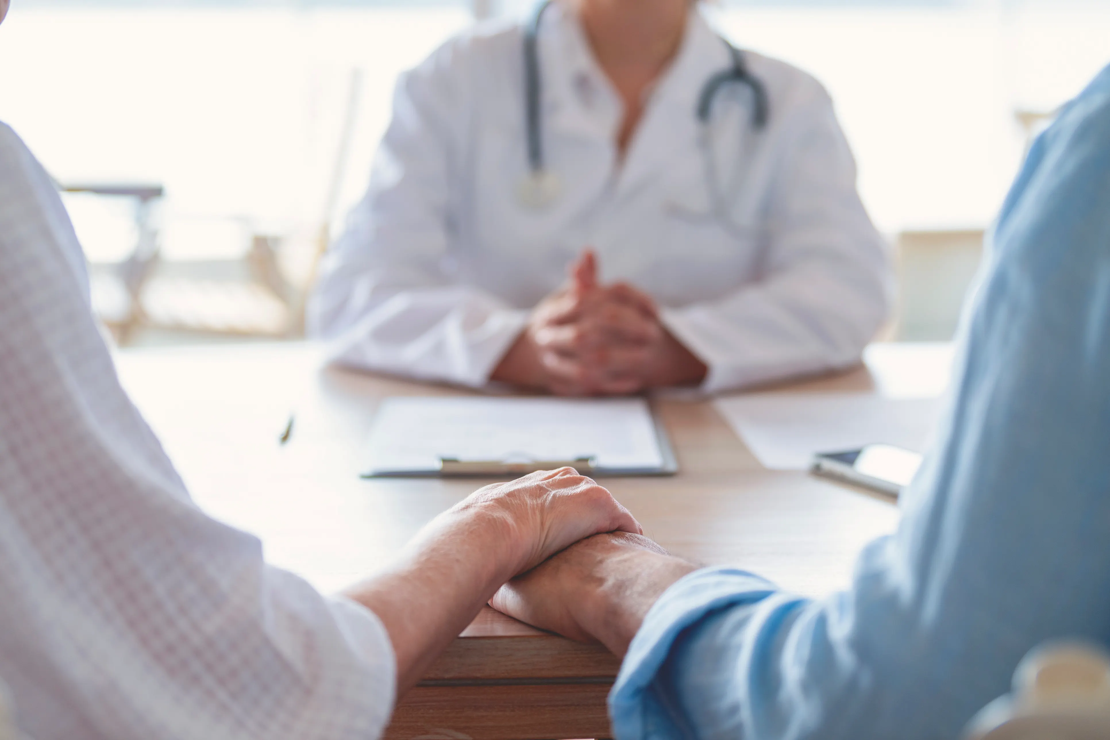 couple holds hands at appointment